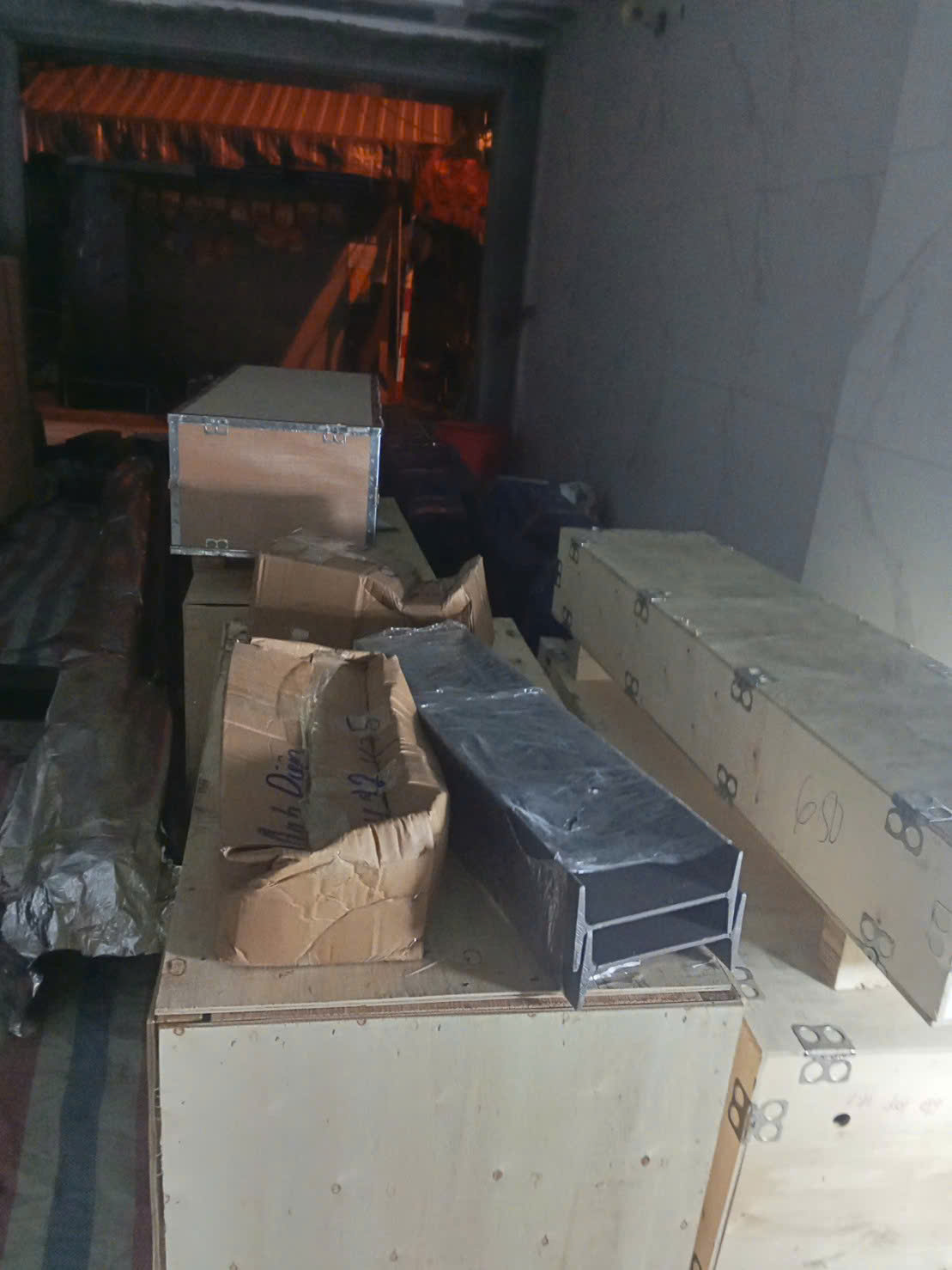 Các thùng gỗ và thùng carton đóng gói hàng hóa xếp trong kho hoặc thùng xe tải